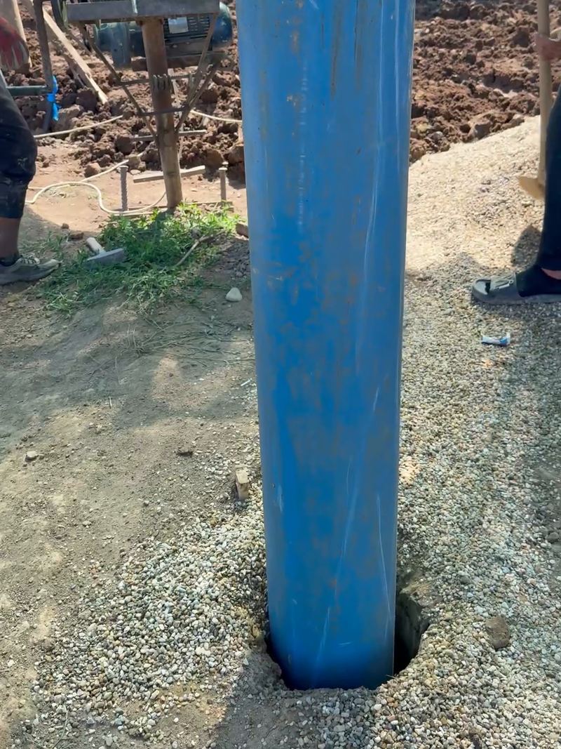 Coloana albastră de PVC a unui puț nou forat de noi în Balotești, ieșită din pământ, cu pietrișul de filtrare turnat în jurul ei
