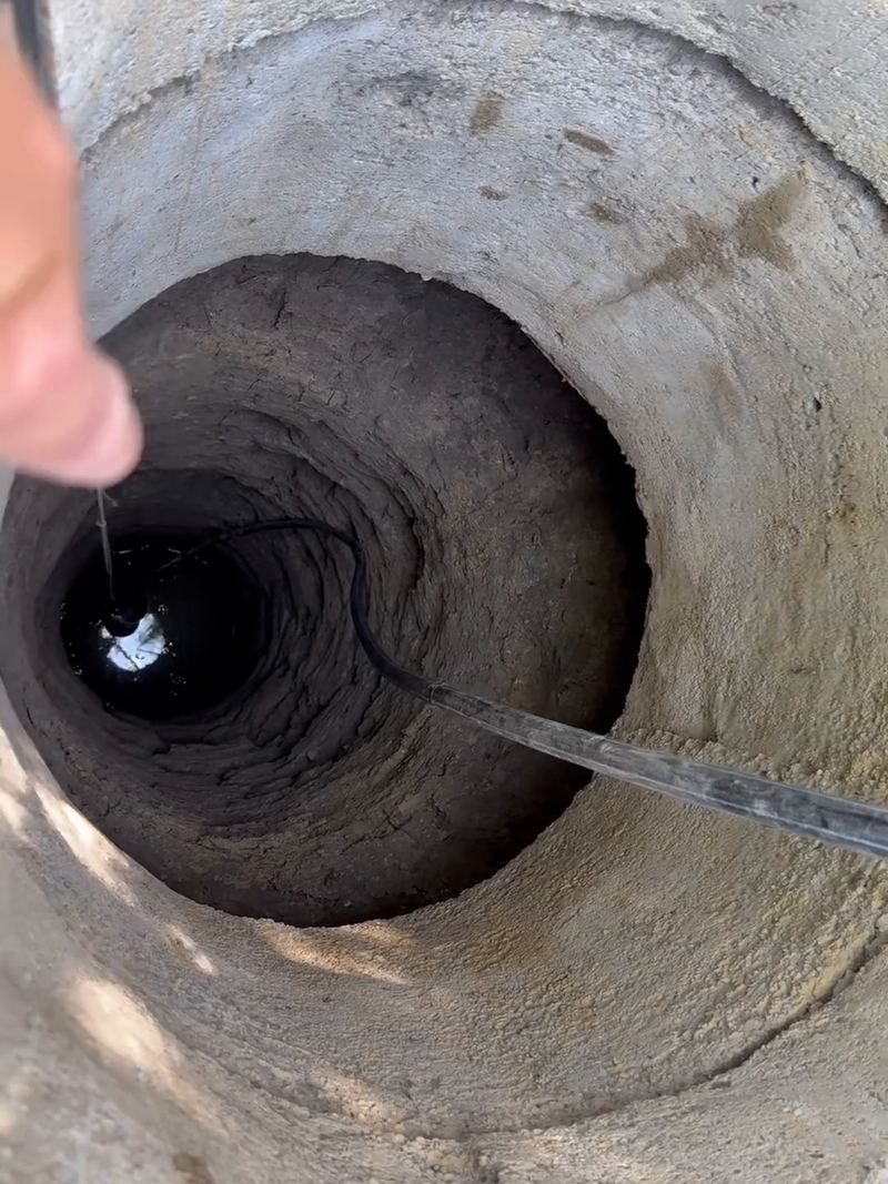Puț vechi din inele de beton, văzut de sus, cu apa jos, înainte de adâncire